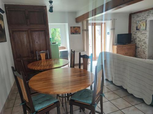 Cette chambre comprend 2 tables et chaises en bois ainsi qu'une télévision. dans l'établissement La Fauconnerie, à Bourgneuf-en-Retz