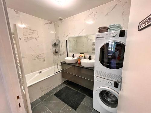 a bathroom with two sinks and a washing machine at La Capucine - Lumineux avec balcon et parking in Saint-Claude