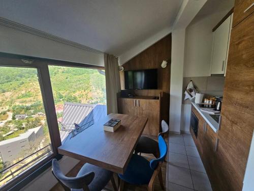 uma cozinha com mesa e cadeiras e uma grande janela em Angela Apartment em Mavrovo