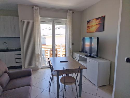 uma sala de estar com uma mesa de jantar e uma televisão em Residenza Adriatica 4 em Roseto degli Abruzzi