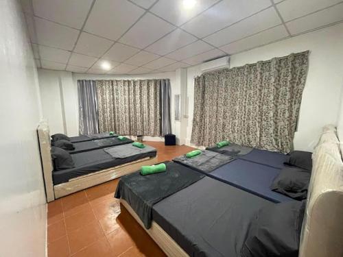 OYO HOME 90768 Flo Inn Motel في تاواو: غرفة نوم بسريرين في غرفة