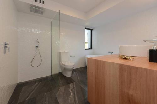 a bathroom with a shower and a toilet and a sink at Modern Sandy Bay Apt - Close to Salamanca & CBD in Sandy Bay
