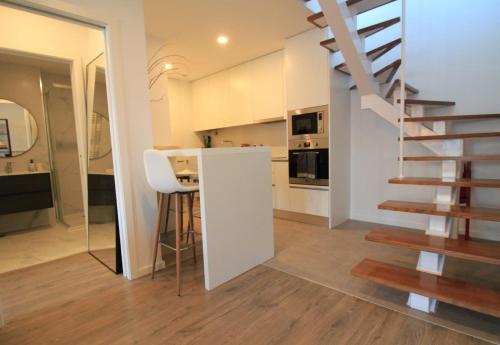 a kitchen with a staircase and a kitchen with white walls at AM in Ponte de Lima