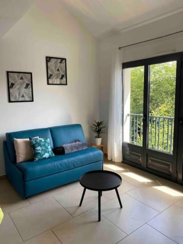 sala de estar con sofá azul y mesa en Appartement cosy à 30 min Paris, Disney, CDG, en Chelles