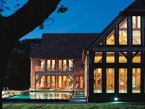 a large house with a pool in front of it at Bespoke Log Cabin in Littlehampton