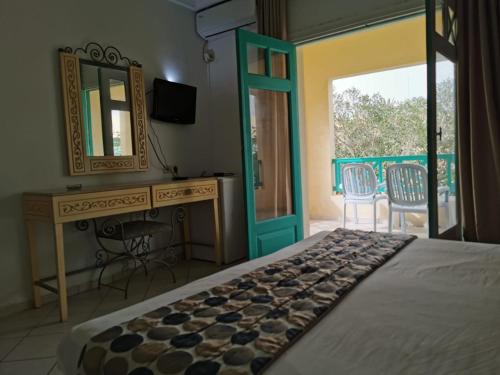 a bedroom with a bed and a desk and a mirror at Hotel Diar Yassine in Midoun