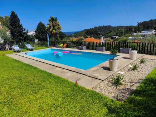 a swimming pool in a yard next to a fence at Casa dos Arcos in Oliveira de Frades
