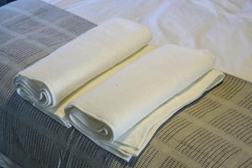 duas toalhas brancas em cima de uma mesa em The Atholls in Melrose em Joanesburgo