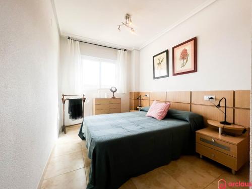 een slaapkamer met een bed met een roze kussen erop bij Como pez en el agua in Oropesa del Mar