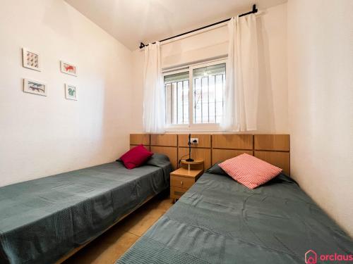 twee bedden in een kamer met een raam bij Como pez en el agua in Oropesa del Mar