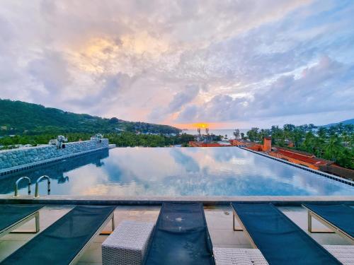 una gran piscina con puesta de sol en el fondo en Meir Jarr Hotel Patong en Patong