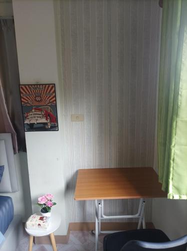 a small room with a wooden table and a chair at JATUPORN A3 in Ban Talat Rangsit