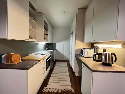 Outokumpu的住宿－Oku Asunto - Jokipohja，厨房铺有木地板,配有白色橱柜。