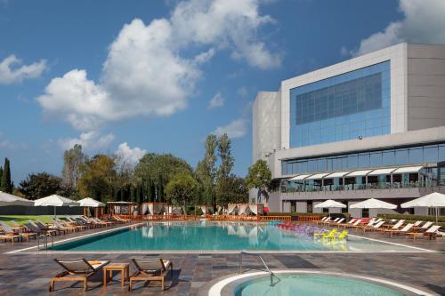 a swimming pool with lounge chairs and a building at Sheraton Istanbul Atakoy Hotel in Istanbul