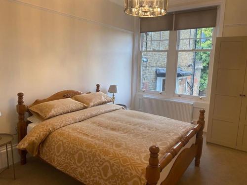 - une chambre avec un lit et une grande fenêtre dans l'établissement Beautiful ground floor flat, à Londres
