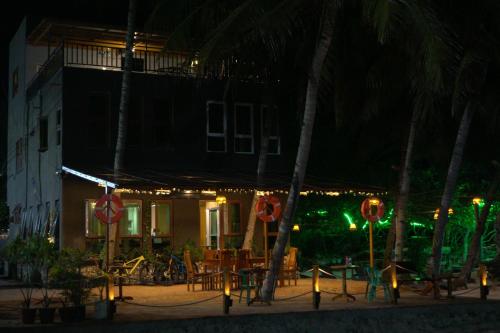 a building with a table and chairs at night at L Cafe Restobar & Lyn's Guest House in San Juan