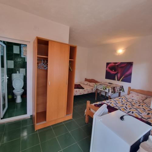 a room with two beds and a toilet in it at Casa Mititelu in Costinesti