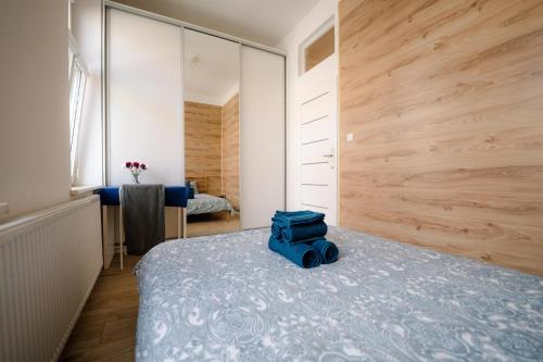 Cosy Balcony Apartment في غروجونتس: غرفة نوم مع حقيبة زرقاء موضوعة على سرير