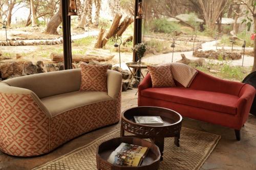 a living room with two chairs and a table at Soroi Larsens Camp in Buffalo Springs  National Reserve