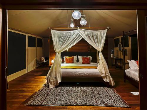 a bedroom with a canopy bed with a rug at Soroi Larsens Camp in Buffalo Springs  National Reserve