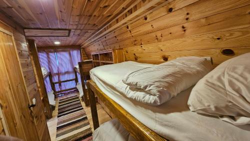 a room with a bed in a wooden cabin at Peaks of Prokletije - Outdoor pool in Gusinje