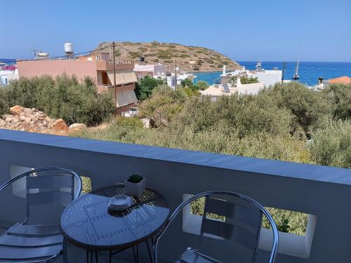 a balcony with a table and chairs and the ocean at Despina Studios in Mochlos