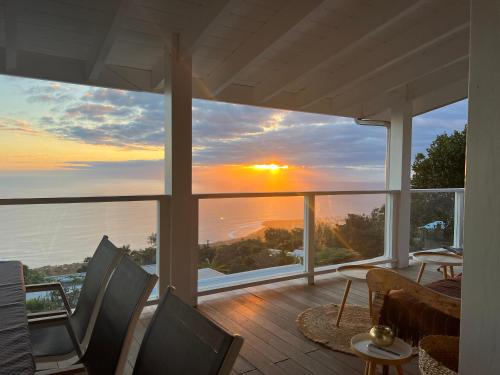 a house with a view of a sunset from a balcony at Le Belvédère - Meublé 4 étoiles in Saint-Leu