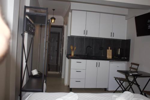 a kitchen with white cabinets and a table in a room at Mr Miller Suites in Istanbul