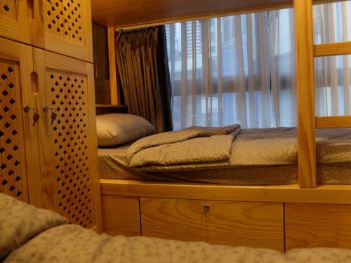a bedroom with two beds and a mirror at HALF Coffee N Dorm in Ho Chi Minh City
