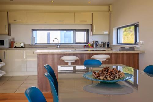 a kitchen with a table with a bowl of pine cones on it at Stac Polly Lodge in Achiltibuie