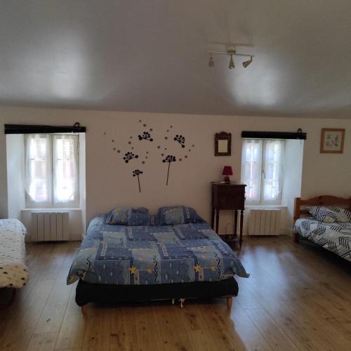 une chambre avec un lit avec une couette bleue dans l'établissement BELLA - chez Florence , chambres d'hôtes, Montrol Sénard, à Montrol-Sénard