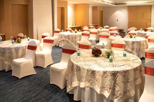 a conference room with tables and chairs with white table cloths at Sheraton Hyderabad Hotel in Hyderabad