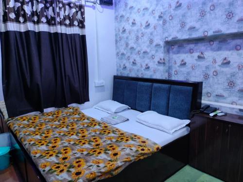 a bedroom with a bed with a floral comforter at Kishan Home Stay in Mathura
