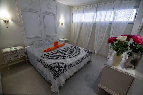 Un dormitorio con una cama con un objeto naranja. en Chaparal Design Apartment en Costa del Silencio