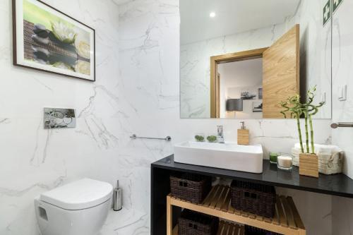 Baño blanco con lavabo y espejo en Elegant Luxury Villa by Ideal Homes en Almancil