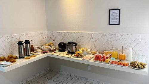 een buffet met veel verschillende soorten ontbijtproducten bij Bálsamo Hotel Marília in Marília