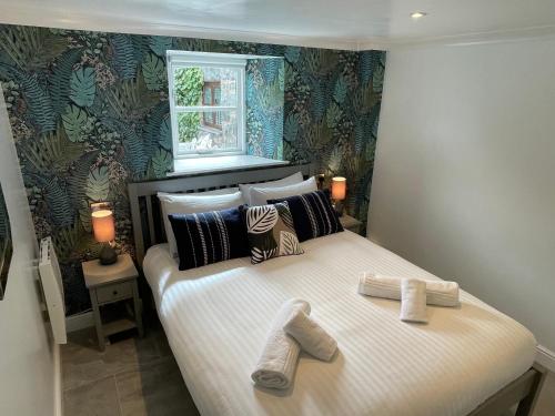 a bedroom with a bed with two shoes on it at Snowdonia Holiday Cottages in Conwy
