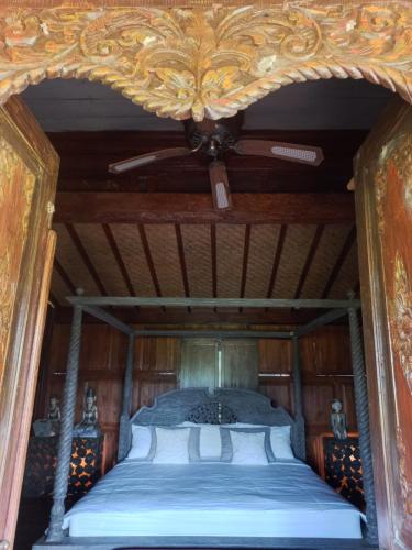 Ce lit se trouve dans un dortoir doté d'un ventilateur de plafond. dans l'établissement Gladak Mesari, à Keramas
