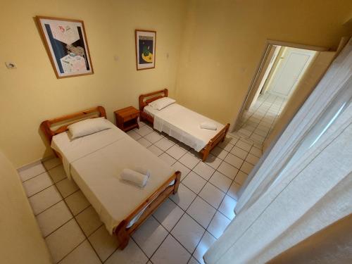 a small room with two beds and a window at Kidonakia Apartments in Agios Ioannis