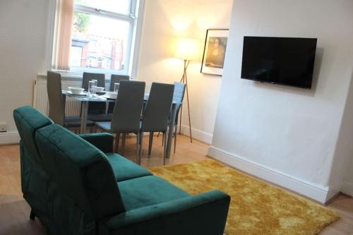 uma sala de estar com um sofá e uma mesa com cadeiras em Grove Bay Inn Home in Leeds - Harehills em Leeds