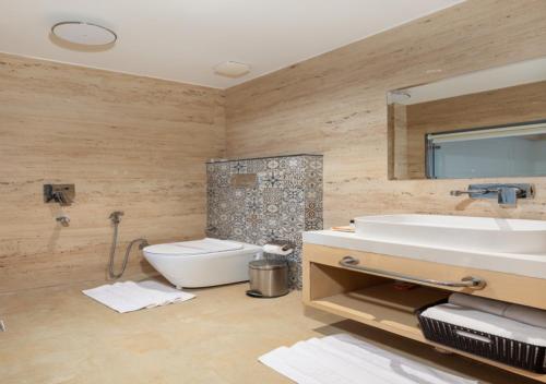 a bathroom with a sink and a toilet at Hotel Caesars Palace in Bhopal