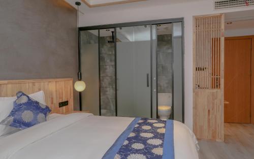 a bedroom with a bed and a sliding glass door at Cozy Boutique Hotel in Zhangjiajie