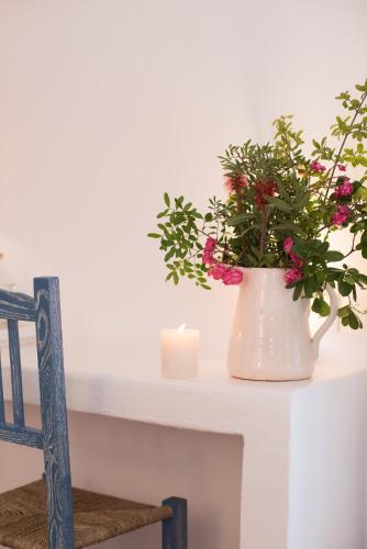 a white vase with flowers and a candle on a table at Octant Vila Monte in Moncarapacho
