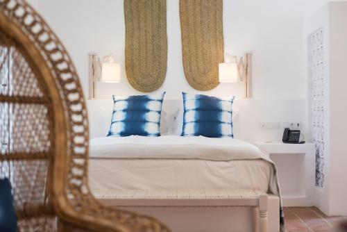 a bedroom with a bed with blue pillows and a mirror at Octant Vila Monte in Moncarapacho