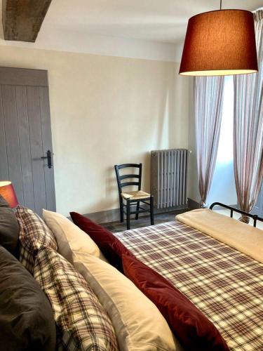 a bedroom with two beds and a chair and a window at Piccola dimora accogliente e molto panoramica in Tagliacozzo