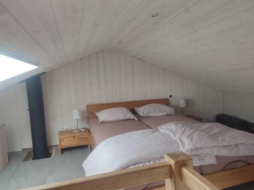 um quarto com uma cama grande e 2 almofadas em Le Mont Céleste em Nonceveux