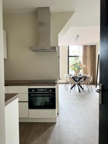 a kitchen with a stove and a dining room at Short Stay Waterpoort in Sneek