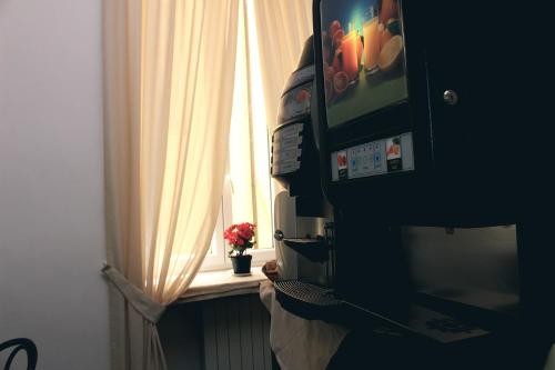 a window with a curtain and a television on a table at Hotel Esperanza in Florence