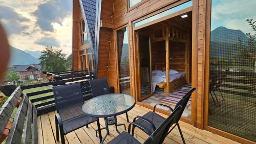 a wooden deck with a table and chairs on a balcony at Peaks of Prokletije - Outdoor pool in Gusinje