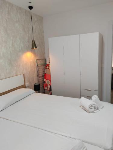 um quarto com uma cama branca e um armário branco em Urbanlux Recinto Ferial em Albacete